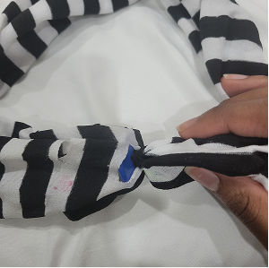 For the first test, I tried to sew in a button on the stocking, and cut out a slit for the button to slip into. This was not very effective, as the button kept slipping out of the slit when tension was applied to the band.